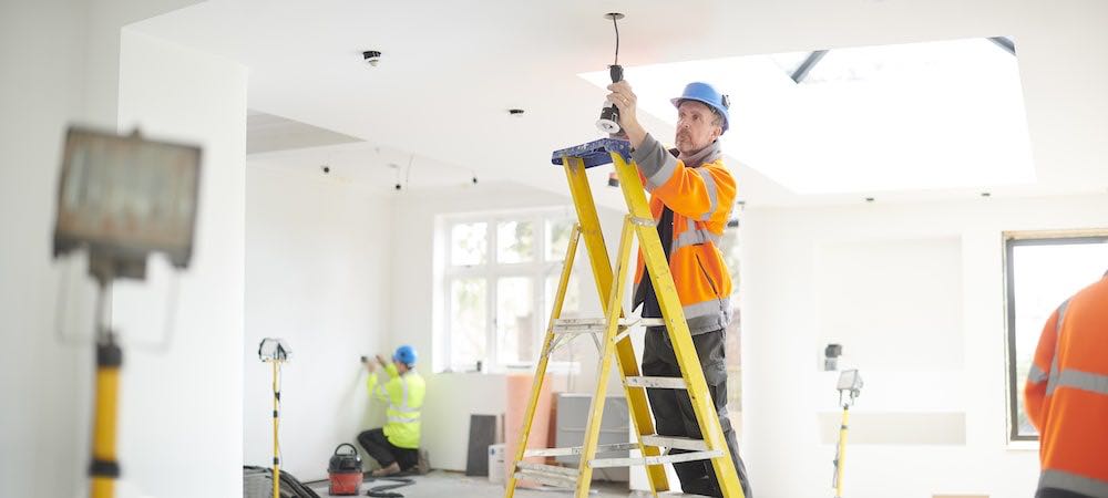 A photo of an attaboy electrician lakewood co electrician working on a light fixture.