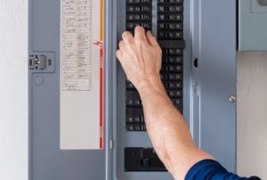 technician inspecting a home circuit breaker